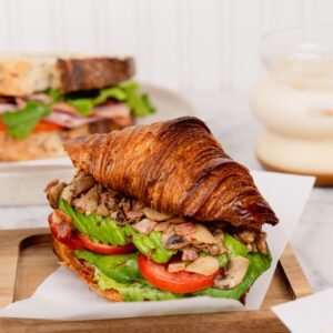 Croissant De champiñones salteados con tocino, lechuga, palta y tomate